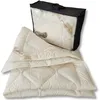 A folded blanket and its storage bag are displayed against a white background. Produktbild-Vorschau