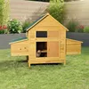 A wooden chicken coop with a green roof sits on a grassy lawn in a backyard setting.