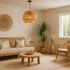 A cozy living room scene with a rattan sofa, coffee table, and a pendant lamp. Náhled obrázku produktu