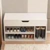 A white shoe cabinet with multiple shelves and a drawer, filled with various shoes and boots. Produktbild-Vorschau