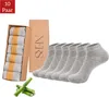 A set of gray ankle socks in a box, along with a separate box of socks and bamboo stalks. Produktbild-Vorschau