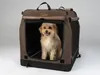 A small dog sits inside a brown and black dog crate. Produktbild-Vorschau