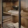 Close-up view of books and a bowl on a wooden shelf inside a cabinet. Produktbild-Vorschau