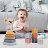 A baby is playing with stacking toys on the floor. Voir les images du produit
