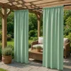 Outdoor patio area with wooden pergola, green curtains, wicker furniture, and potted plants. Podgląd zdjęcia produktu