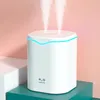 A white humidifier with two streams of mist rising from the top, set against a pink and teal background with white blocks. Náhľad obrázku produktu