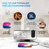 A digital alarm clock with projection capabilities, shown on a marble surface with a smartphone charging in front of it. The image highlights various features of the clock. Produktbild-Vorschau