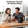 A couple enjoying coffee and cake at a table with a Clatronic kettle in the background. Produktbild-Vorschau