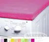 A pink cover is placed on top of a white washing machine. Voir les images du produit