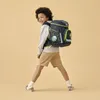 A young boy wearing a backpack and walking. Podgląd zdjęcia produktu