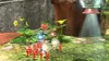A group of red Pikmin and two Olimar characters are gathered around some plants, with a spaceship hovering above and shining a light down. Produktbild-Vorschau
