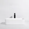 A white ceramic vessel sink with a black faucet against a white background. Podgląd zdjęcia produktu