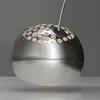 A close-up shot of a modern, spherical pendant light with a perforated top and a brushed metal finish. Anteprima dell’immagine prodotto