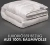 A folded white duvet or comforter is shown against a dark gray background. Text overlays the bottom portion of the image. Produktbild-Vorschau