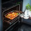 Carrots are being roasted in a glass baking dish inside an oven. Podgląd zdjęcia produktu