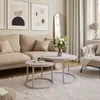 A cozy and modern living room with a sofa, coffee tables, and artwork. Náhľad obrázku produktu