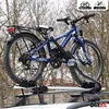 A blue bicycle is mounted on a car roof rack, with trees in the background. Náhľad obrázku produktu