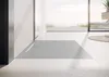 A modern bathroom with a large window overlooking the ocean, featuring a sleek, low-profile shower tray. Produktbild-Vorschau