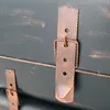 Close-up of a vintage-style trunk or mailbox with copper-colored metal clasps and straps. Produktbild-Vorschau