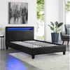 A bedroom scene with a black upholstered bed frame featuring blue LED lighting. Produktbild-Vorschau