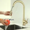 A person is washing an apple under a gold kitchen faucet. Náhled obrázku produktu