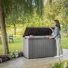 A woman is opening a large gray storage box in a garden setting. Podgląd zdjęcia produktu