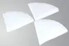 Three white, wedge-shaped filters arranged in a pinwheel formation against a light gray background. Produktbild-Vorschau
