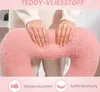 Hands touching a pink teddy fleece pillow. Produktbild-Vorschau