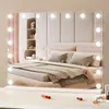 A vanity mirror with lights is placed on a dresser in front of a bed. Anteprima dell’immagine prodotto