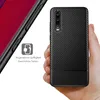 A hand holding a black carbon-look phone case, with a partial view of a red smartphone on the left. Náhľad obrázku produktu