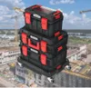 A stack of toolboxes on a wheeled platform, set against a backdrop of a construction site with cranes and buildings under construction. Náhled obrázku produktu
