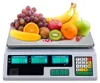 A digital scale with various fruits on it. Voir les images du produit