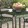 A green metal table and chairs set in an outdoor setting with a bowl of apples and cups of coffee. Produktbild-Vorschau