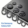 A close-up view of multiple camera lens protectors for a Samsung Galaxy S23 phone, arranged on a reflective surface. Produktbild-Vorschau