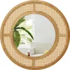 A round mirror with a rattan frame and a wooden border, reflecting a room with a palm tree and a sofa. Podgląd zdjęcia produktu