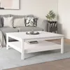 A white square coffee table with a shelf underneath, placed in a living room setting with a sofa and rug. Náhľad obrázku produktu