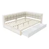 A white and natural wood daybed with beige upholstered headboard and two pull-out drawers, shown from a slightly elevated diagonal angle against a white background. Náhled obrázku produktu