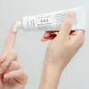 A hand is squeezing a tube of cream onto a finger. Podgląd zdjęcia produktu