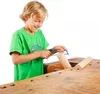 A young boy is using a small saw to cut a wooden dowel on a workbench. Produktbild-Vorschau