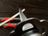 A close-up view of a katana and wakizashi set, with the blades and guards prominently featured against a dark, draped background. Voir les images du produit