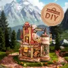 A detailed 3D wooden model of a gift factory, set against a backdrop of mountains and trees, with a circular 'Mechanical DIY' logo in the upper right corner. Podgląd zdjęcia produktu