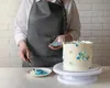 A person decorating a cake with blue sprinkles. Anteprima dell’immagine prodotto