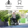 A woman rides a bicycle past planters with greenery and flowers. Produktbild-Vorschau