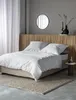 A bedroom scene with a bed, headboard, and decor. Produktbild-Vorschau