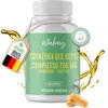 A bottle of Coenzym Q10 Ubichinon Komplex supplements with a tag and oil splashes. Náhľad obrázku produktu