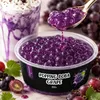 Popping Boba Traube wird mit einem Loeffel in ein lila Bubble-Tea-Getraenk gegeben Podgląd zdjęcia produktu