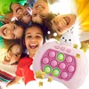 A group of children are looking down at the camera, smiling and laughing. In the foreground, a pink toy game with a rabbit on top is visible. Produktbild-Vorschau