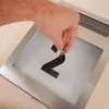 A hand is shown applying a black number '2' sticker to a solar-powered house number light fixture. Produktbild-Vorschau