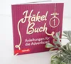 A close-up shot of a book cover with a decorative plant in the foreground. Produktbild-Vorschau