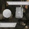 A person's hand is visible on a bicycle handlebar, with a waterproof bag attached to the rear rack. Raindrops are visible on the bag and in the background. Produktbild-Vorschau
